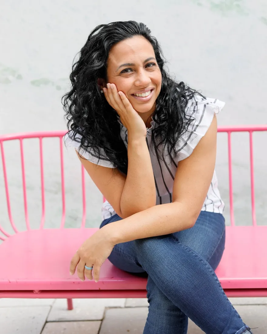 Tina smiling while seated outdoors